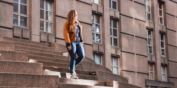 Frau in Jeans auf Treppe