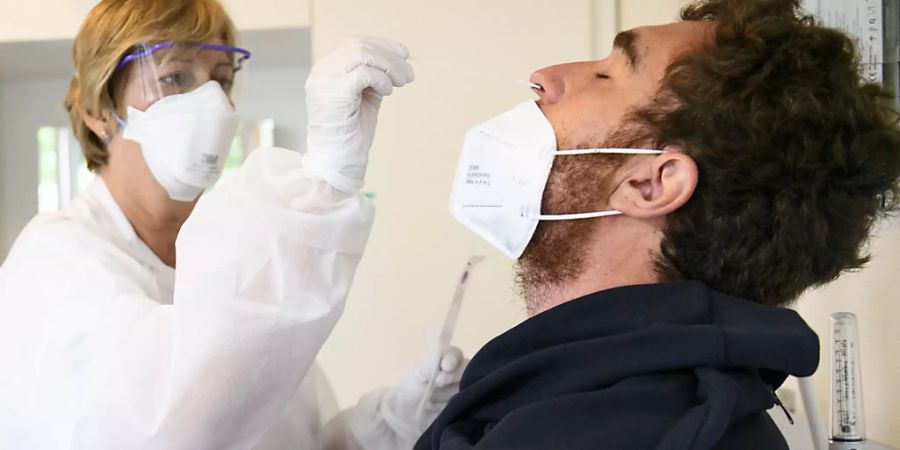 Eine Gesundheitsmitarbeiterin macht einen Nasenabstrich, um den Patienten auf Sars-CoV-2 zu testen. (Archivbild)