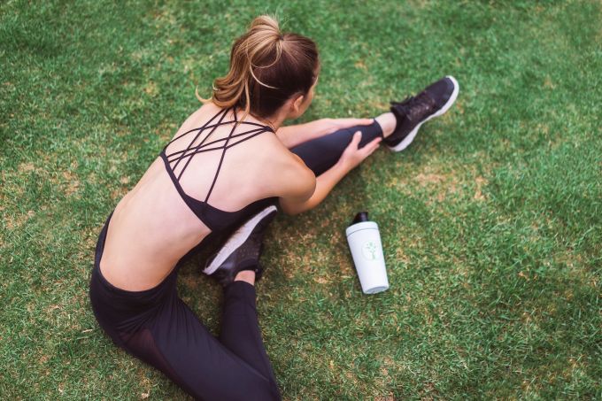 Wie oft treibe ich wirklich Sport: Kann es auch zu viel sein? Frau Rasen DehnÜbung Sport Flasche schwarz