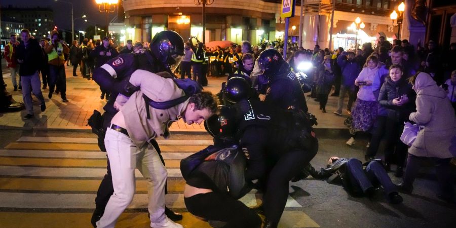 Polizisten versuchen, eine Demonstration in Moskau niederzuschlagen.