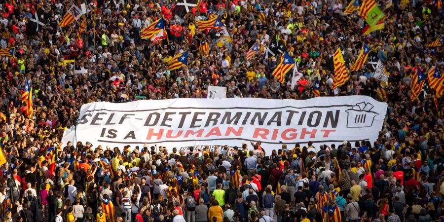 Tausende Menschen mit einem Banner «Selbstbestimmung ist ein Menschenrecht» marschieren im Oktober vom Plaça Catalunya zum Parlament von Katalonien, um ein Referendum sowie demokratische Rechte zu verlangen und die spanische Regierung zu kritisieren.