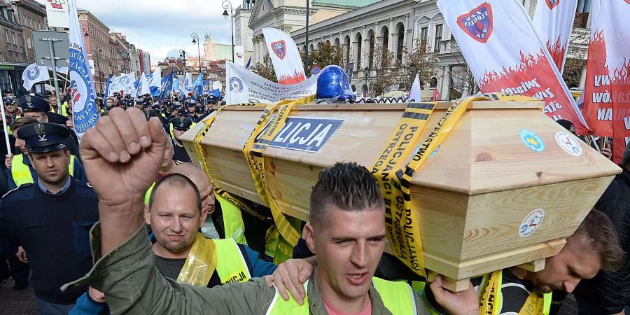 Demonstranten tragen während eines Protests symbolisch einen Sarg der Polizei auf den Schultern.