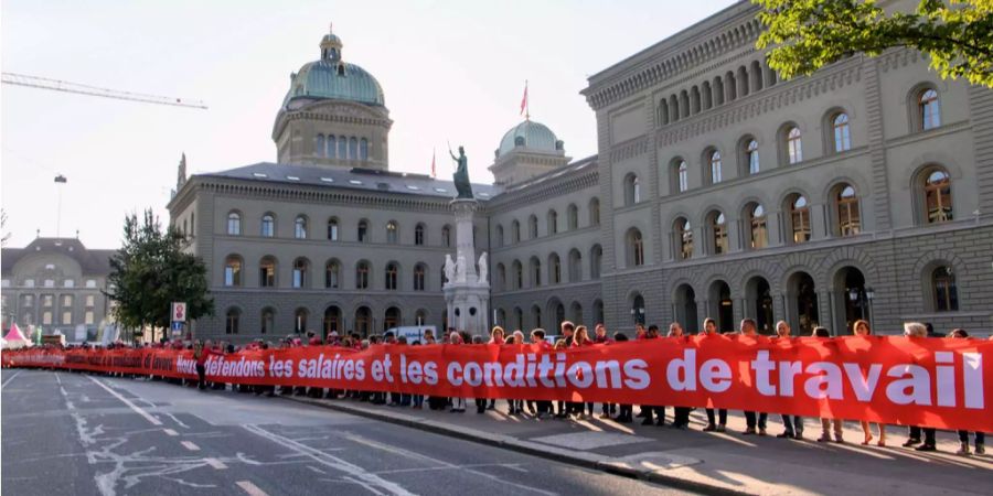 Menschen demonstrieren während der Aktion von Arbeitnehmenden zum Arbeitnehmerrecht «Rote Linie Arbeitnehmerrechte».