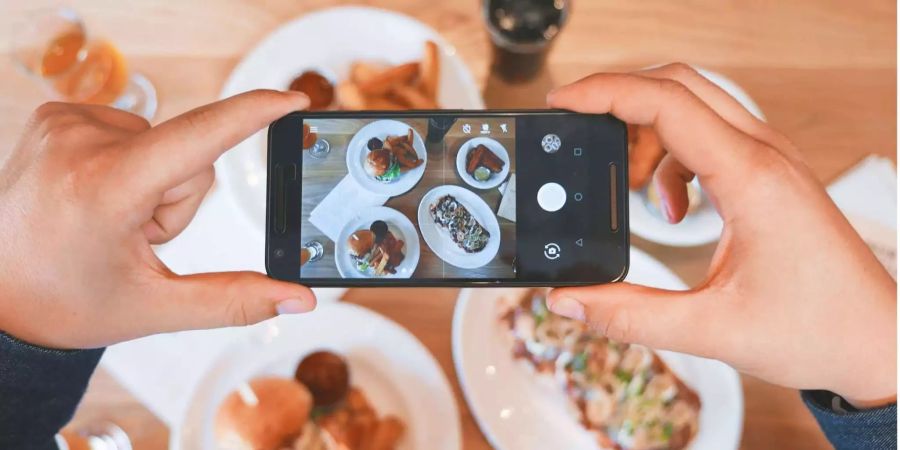 Viele Menschen fotografieren gerne ihr essen mit dem Handy.