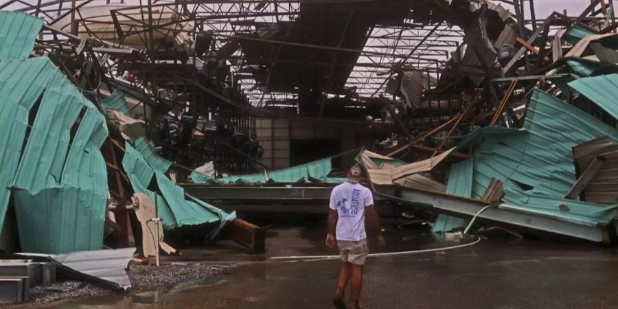 Ein Mann steht vor einem zerstörten Boots-Lagerhaus in Mexico Beach.