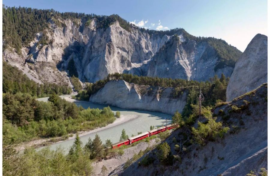 Ein Zug der Rhätischen Bahn fährt durch einen Teil der Rheinschlucht in Graubünden.