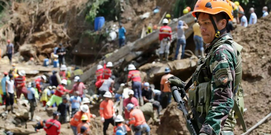 Ein Polizist überwacht die Suche nach Opfern an dem Ort in Itogon im Norden der Philippinen, wo eine Schlammlawine, verursacht durch den Taifun «Mangkhut», eine Unterkunft von Bergbauarbeitern begraben hat.