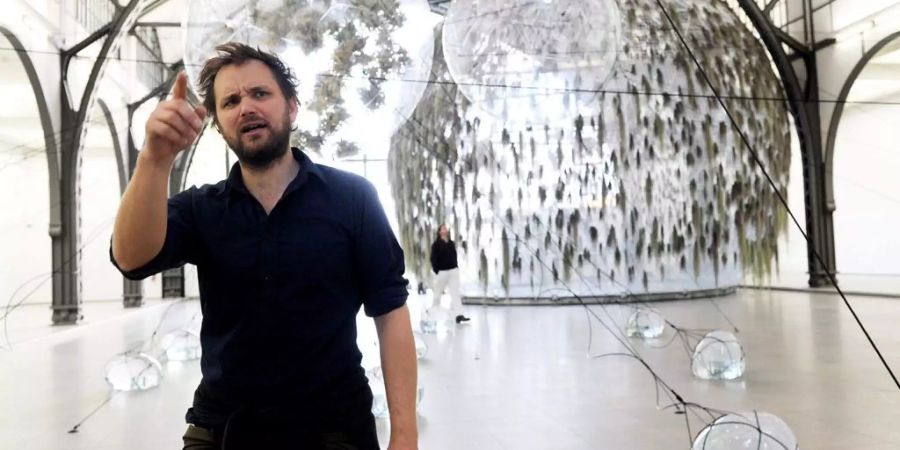 Tomás Saraceno posiert während einer seiner Ausstellungen.