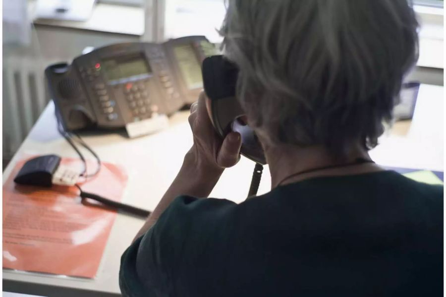 Eine ältere Frau am Telefon - Keystone