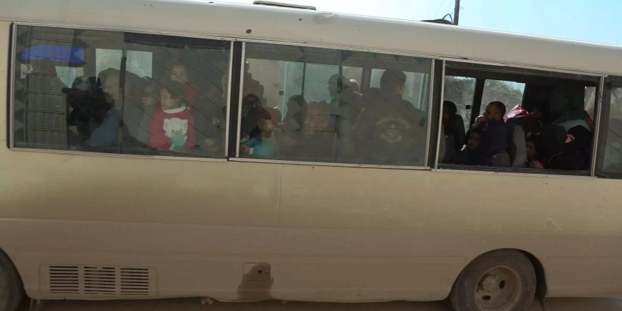 Menschen sitzen in einem Bus der Hilfsorganisation Roter Halbmond, der sie aus Ost-Ghuta wegbringen soll.