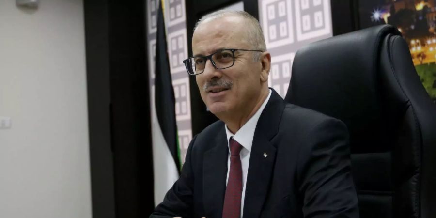 Rami Hamdallah sitzt an seinem Tisch.