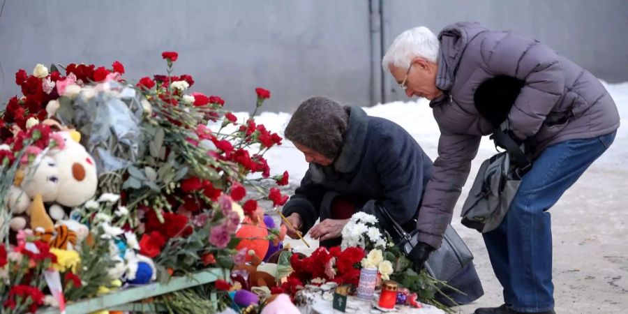 Angehörige legen Blumen nieder.