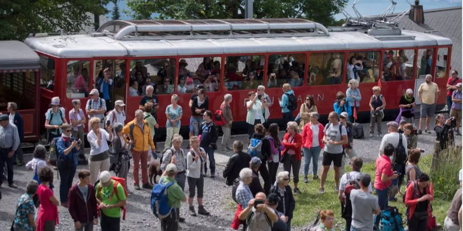 Touristen steigen aus einer Bahn aus.