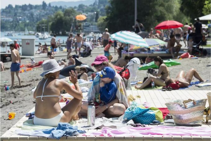 Kinder und Erwachsene geniessen das herrliche Sommerwetter im Schwimmbad Mythenquai - Keystone Kinder und Erwachsene geniessen das herrliche Sommerwetter im Schwimmbad Mythenquai - Keystone