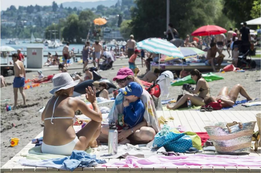 Kinder und Erwachsene geniessen das herrliche Sommerwetter im Schwimmbad Mythenquai - Keystone