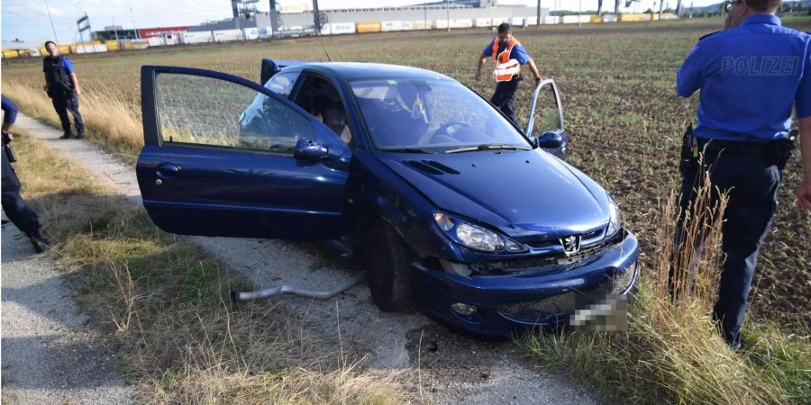 Das Auto kam auf einem Feldweg zum Stehen: Polizisten untersuchen das Auto und den Unfallort.