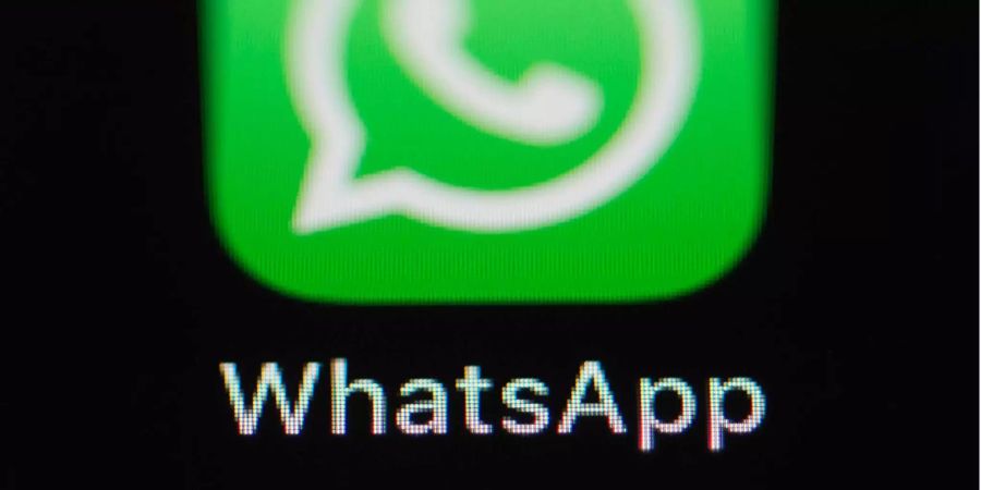 Das Logo der Messenger-App WhatsApp ist auf dem Bildschirm eines iPhones zu sehen.