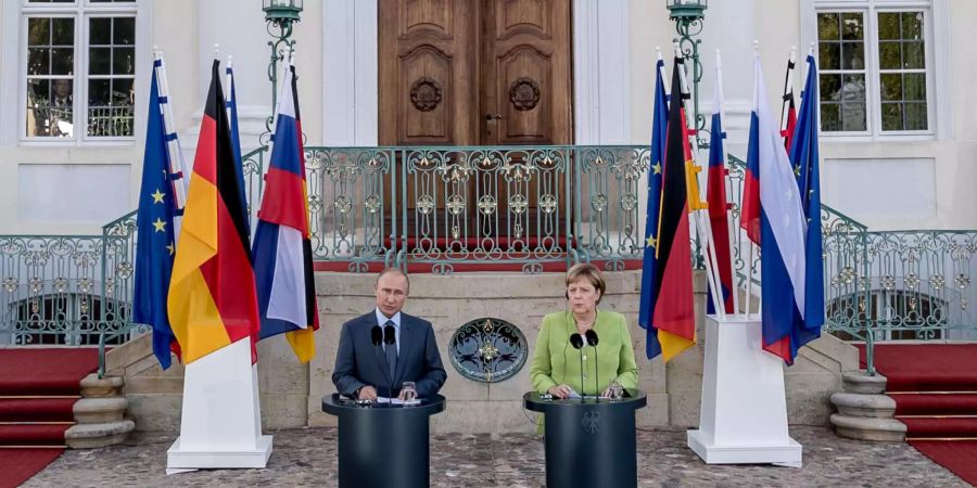 Die deutsche Bundeskanzlerin Angela Merkel (CDU) steht neben Wladimir Putin, Präsident von Russland, vor Schloss Meseberg.