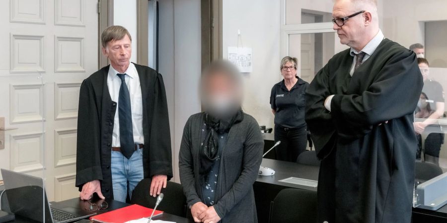 Die Angeklagte IS-Rückkehrerin aus Bremen steht zwischen ihren Verteidigern Jacob Hösl (r) und Johannes Pausch in einem Saal des Oberlandesgericht.