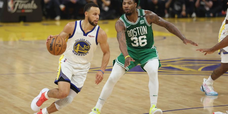 Stephen Curry (l), Guard der Golden State Warriors, zieht zum Korb gegen Marcus Smart, Guard der Boston Celtics.