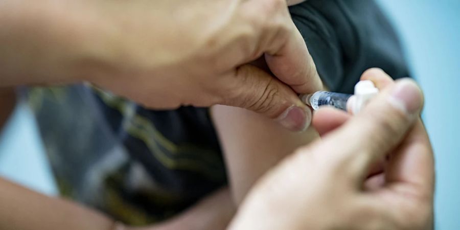 ARCHIV - Ein Kinderarzt verabreicht einem Jungen einem Auffrischung eines dtp-Kombinationsimpfstoff. Die Routine-Impfungen bei Kindern sind wegen der Corona-Pandemie und Problemen in Konfliktregionen so stark zurückgegangen wie nie zuvor in etwa 30 Jahren. Foto: Fabian Sommer/dpa