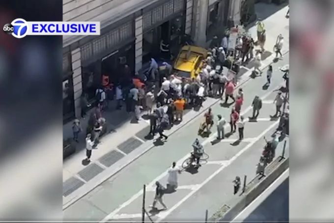 Nach dem Unfall versuchen Menschen, die verletzten Personen von unter dem Taxi zu retten. Manhattan