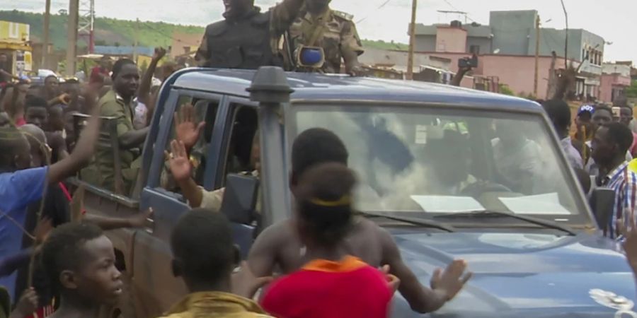 SCREENSHOT - Malische Soldaten werden bei ihrer Ankunft in einem Militärlager bejubelt. Foto: Moustapha Diallo/AP/dpa