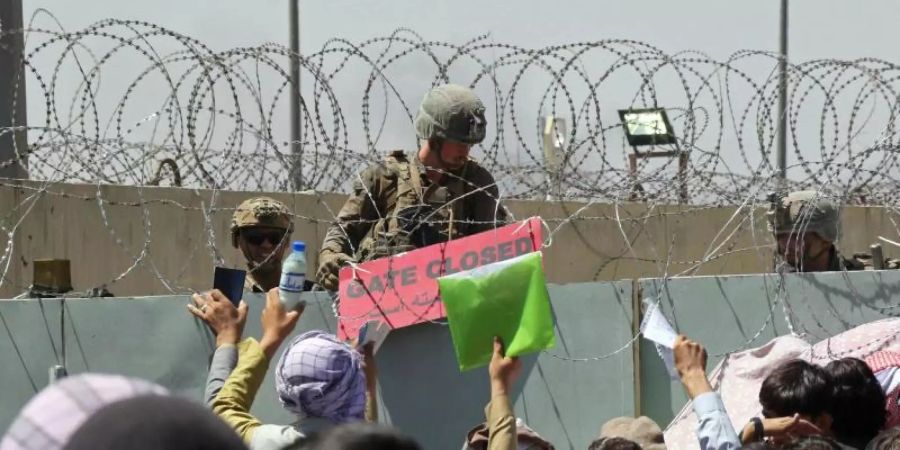 Hunderte Menschen hoffen vor einem Evakuierungskontrollpunkt auf dem Gelände des Flughafens von Kabul darauf, ausser Landes zu gelangen. Foto: Wali Sabawoon/AP/dpa