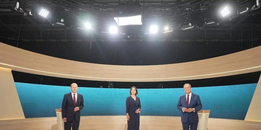 Kanzlerkandidat Olaf Scholz (SPD, l-r), Kanzlerkandidatin Annalena Baerbock (Bündnis90/Die Grünen) und Kanzlerkandidat Armin Laschet (CDU) stehen im Fernsehstudio. Foto: Michael Kappeler/dpa-Pool/dpa