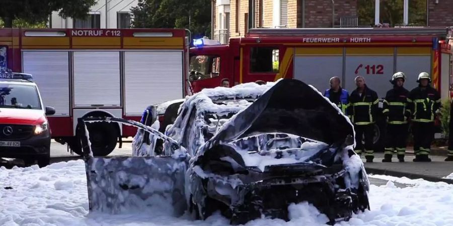 Vom Löschschaum bedeckt steht ein Auto nach einer Explosion auf der Strasse im nordrhein-westfälischen Hürth. Foto: TNN/dpa