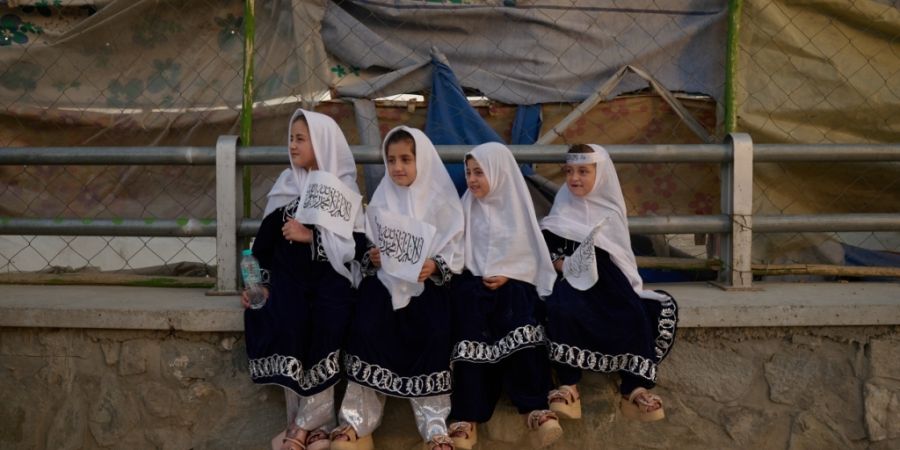 dpatopbilder - Vier junge Mädchen in einheitlichen Outfits halten am Vorabend des fünften Jahrestags des US-Abzugs und des Beginns der Taliban-Herrschaft Taliban-Fahnen in den Händen...