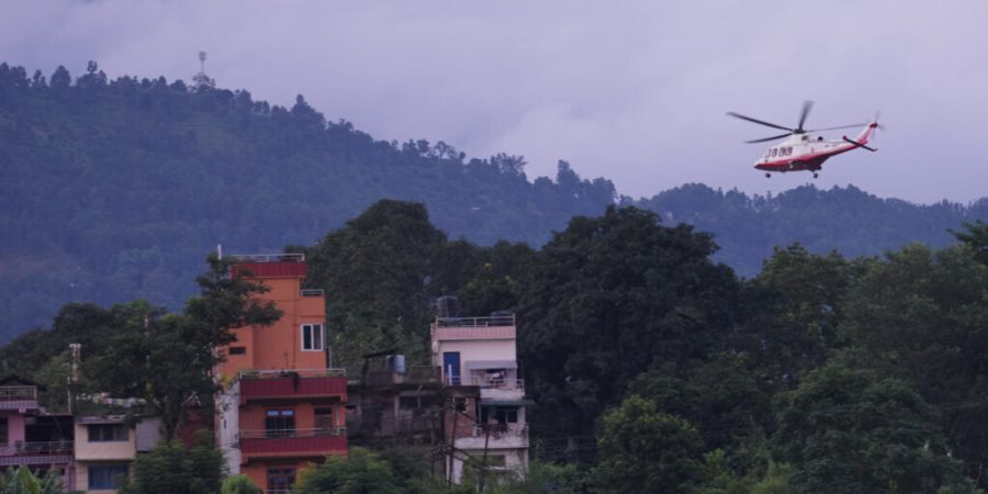 Ein Hubschrauber führt inmitten der Verwüstungen, die Sturzfluten im nepalesischen Distrikt Nuwakot hinterlassen haben, einen Rettungseinsatz durch. Foto: Rajesh Kumar Singh/AP/dpa/Ar...