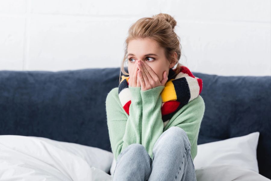 frau mit erkältung im bett