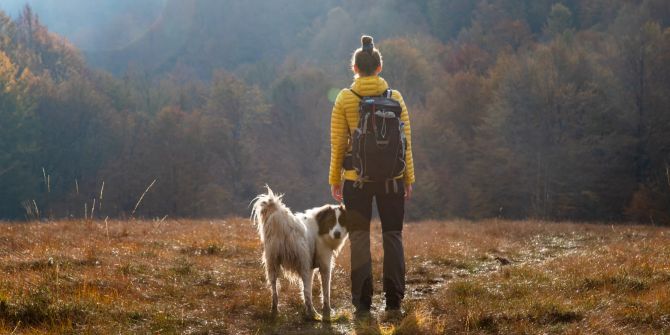 Frau mit Hund beim Wandern