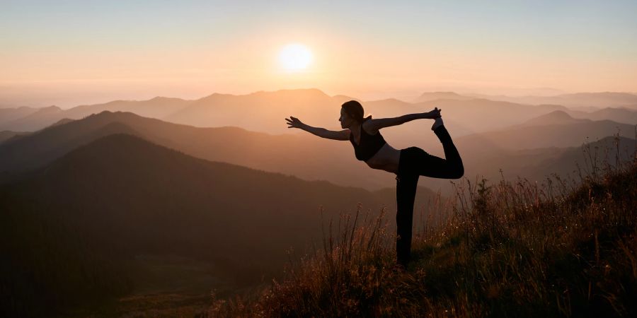 Fuau maht Yoga in den Bergen mit Aussicht