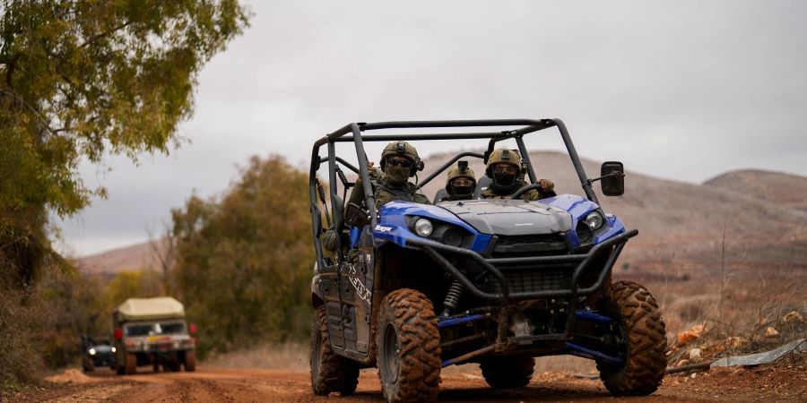 Israelische Soldaten fahren in einem Gebiet nahe der israelisch-libanesischen Grenze entlang.