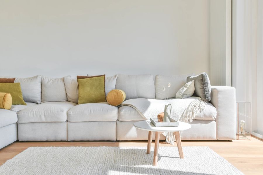 Helles Sofa mit farbigen Kissen.