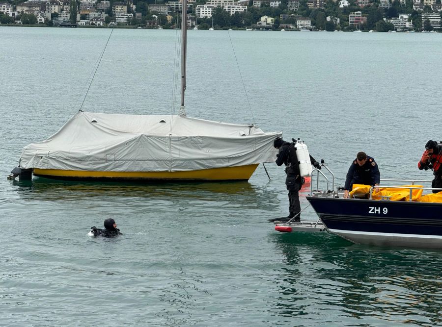 Polizeitaucher gehen ins Wasser.