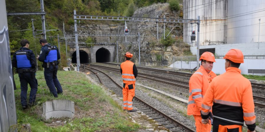 Polizisten und Bahnmitarbeiter in der Nähe des Ursprungs des Kabelbrands bei den Tunneln von Eclépens.