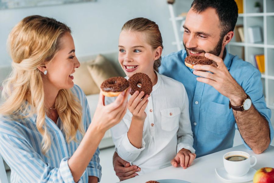 familie, jeder beisst in einen donut, heimische küche