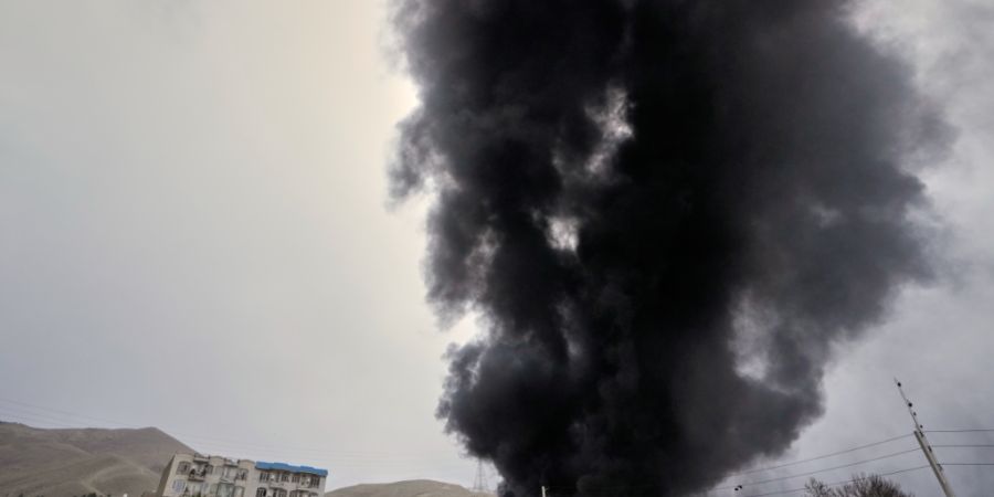 Eine dicke Rauchwolke, die von einem amerikanisch-israelischen Angriff auf ein Öllager am späten Samstag stammt, ist am bewölkten Himmel über Teheran zu sehen. Foto: Vahid Salemi/AP/dpa