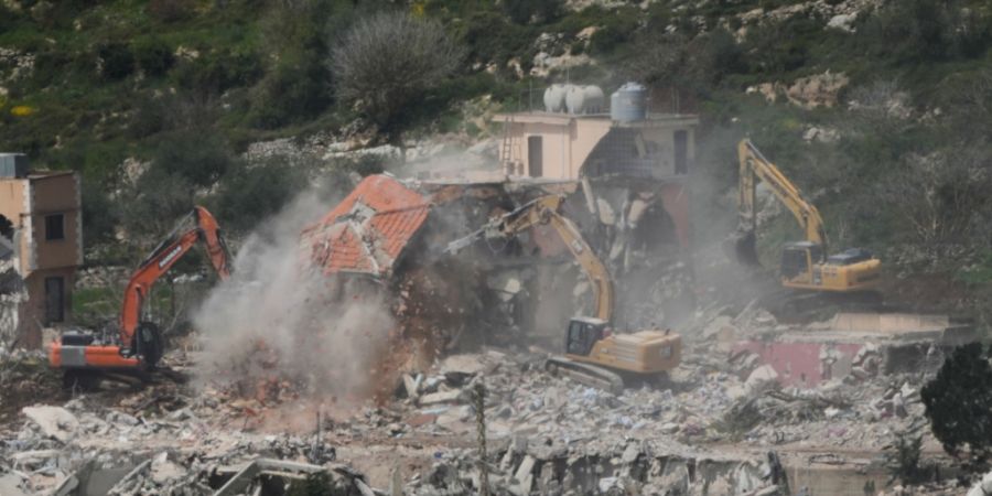 ARCHIV - Israelische Bulldozer zerstören Häuser im Südlibanon, gesehen von Nordisrael aus. Foto: Ariel Schalit/AP/dpa