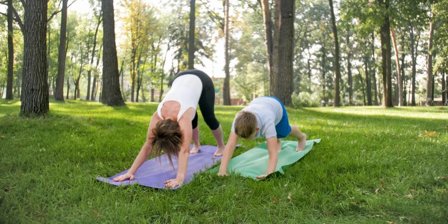 Frau und Kind machen Yoga