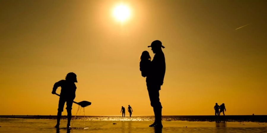 Vater mit Kindern am Strand