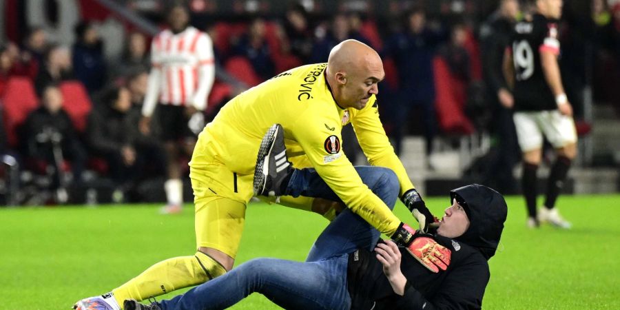 Ein PSV-Fan (r) griff Sevilla-Torhüter Marko Dmitrovic während dem Spiel in der Europa League an.