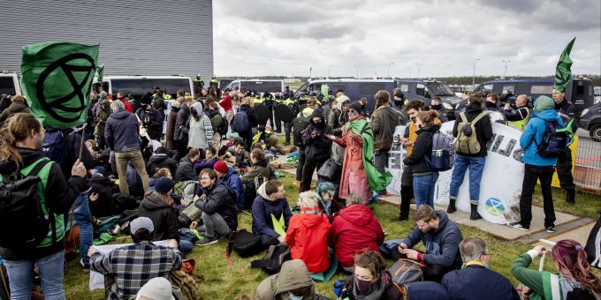epa10542359 Several hundred climate activists from Extinction Rebellion campaigning on the grounds of Eindhoven Airport in Eindhoven, the Netherlands, 25 March 2023. The activists cut a hole in a fence on Castendijkweg and climbed through it. The group was stopped by the Marechaussee and the police to prevent them from entering the runway. EPA/Sem van der Wal Extinction Rebellion protests at Eindhoven Airport