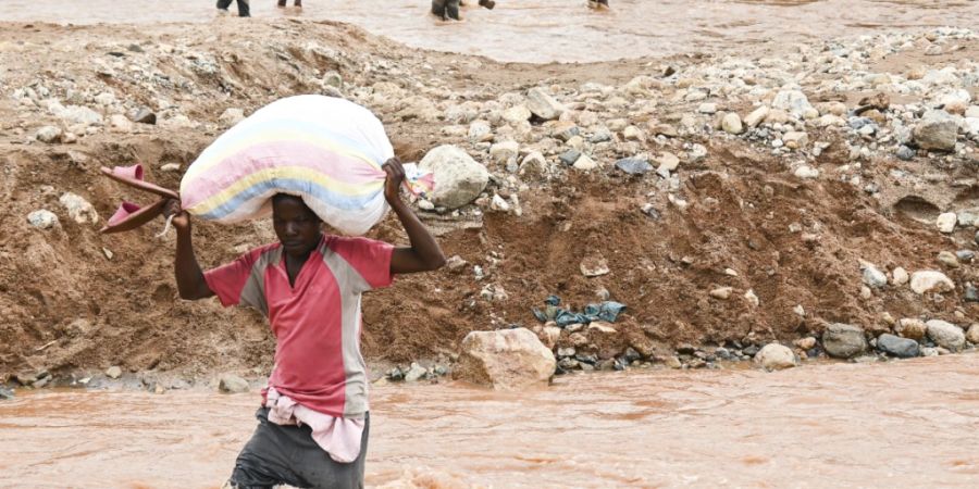 Ein Mann watet durch einen überschwemmten Fluss, der durch die schweren Regenfälle des Tropensturms «Freddy» entstanden ist. In Malawi sind aufgrund des aussergewöhnlich langanhaltenden Tropensturms «Freddy» mehr als 400 Menschen gestorben und mehrere Hundert Menschen sind noch auf der Flucht oder werden vermisst. Foto: Thoko Chikondi/AP