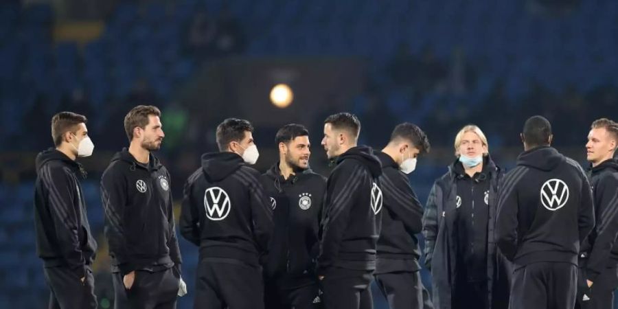 Die DFB-Spieler stehen vor dem Aufwärmen auf dem Rasen. Foto: Christian Charisius/dpa