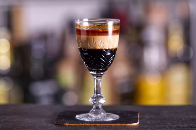 Die unterschiedliche Dichte der Flüssigkeiten sorgt dafür, dass die Schichten im Glas getrennt bleiben. Für den «B52» werden Kaffeelikör, Baileys und Bitterorangenlikör verwendet. Glas Cherry Cocktail gebaut