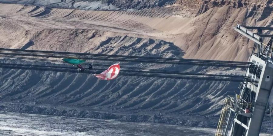 Eine Fahne und Ausrüstungsgegenstände hängen in den Seilen eines Absetzers im Braunkohletagebau Garzweiler II. Foto: Henning Kaiser/dpa